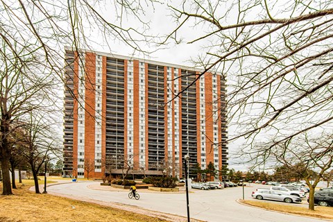 a tall apartment building with cars parked in front of it